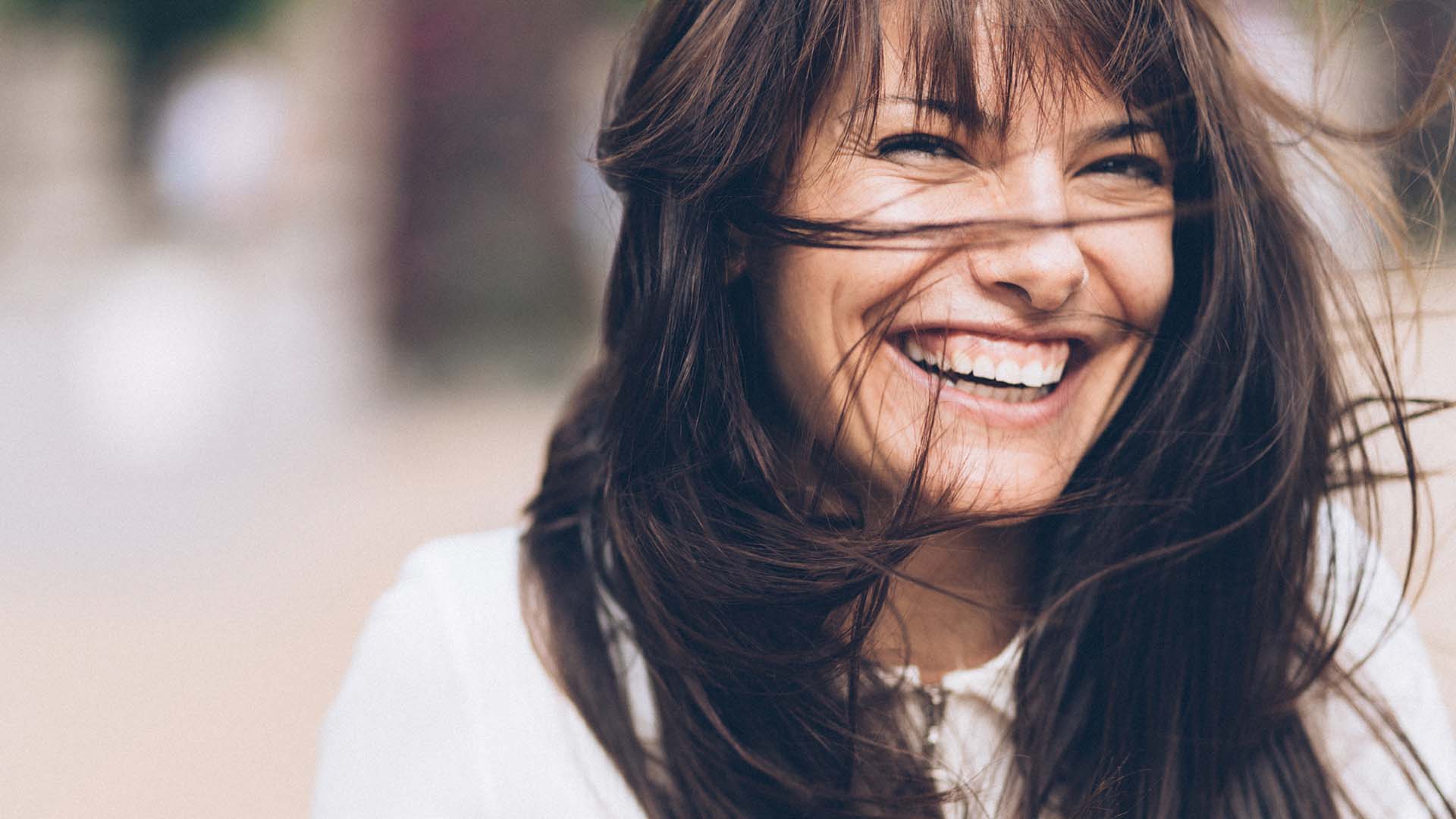 Frau lächelt glücklich mit schönen Zähnen nach ästhetischer Zahnbehandlung in Dresden-Löbtau