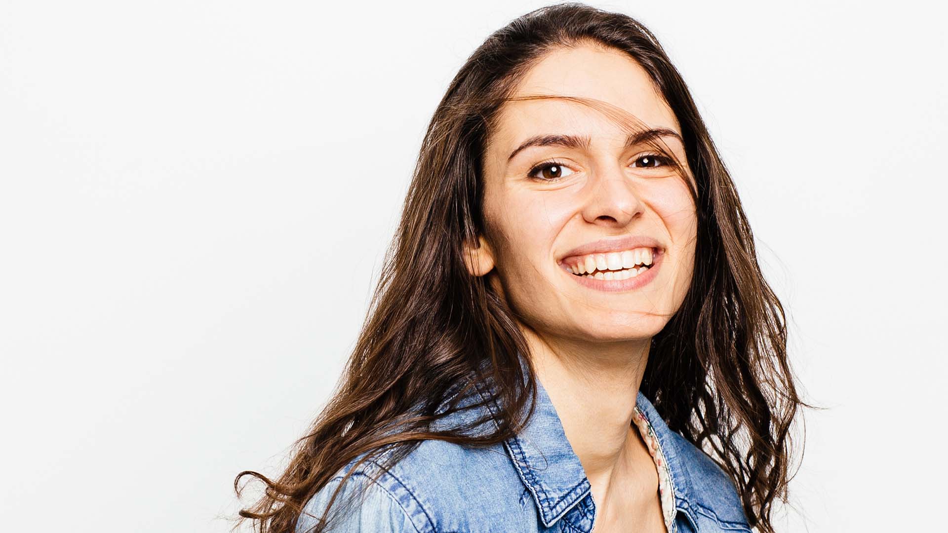 Frau lächelt mit perfekten Zähnen nach Behandlung bei ästhetischer Zahnheilkunde Dresden